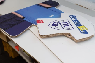 Konturgefräste Displayteile mit Vereinsmotiven auf dem Werktisch